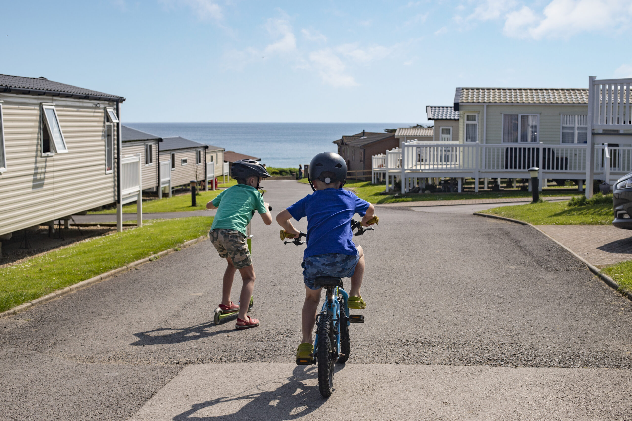 children cycling towards the sea past caravans at golden cap holiday park