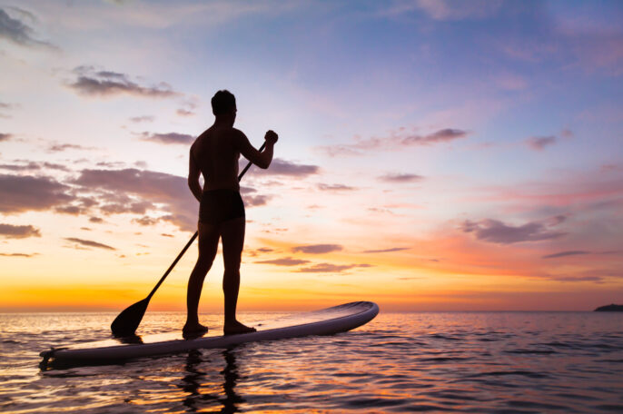 stand up paddleboading at sunset dorset