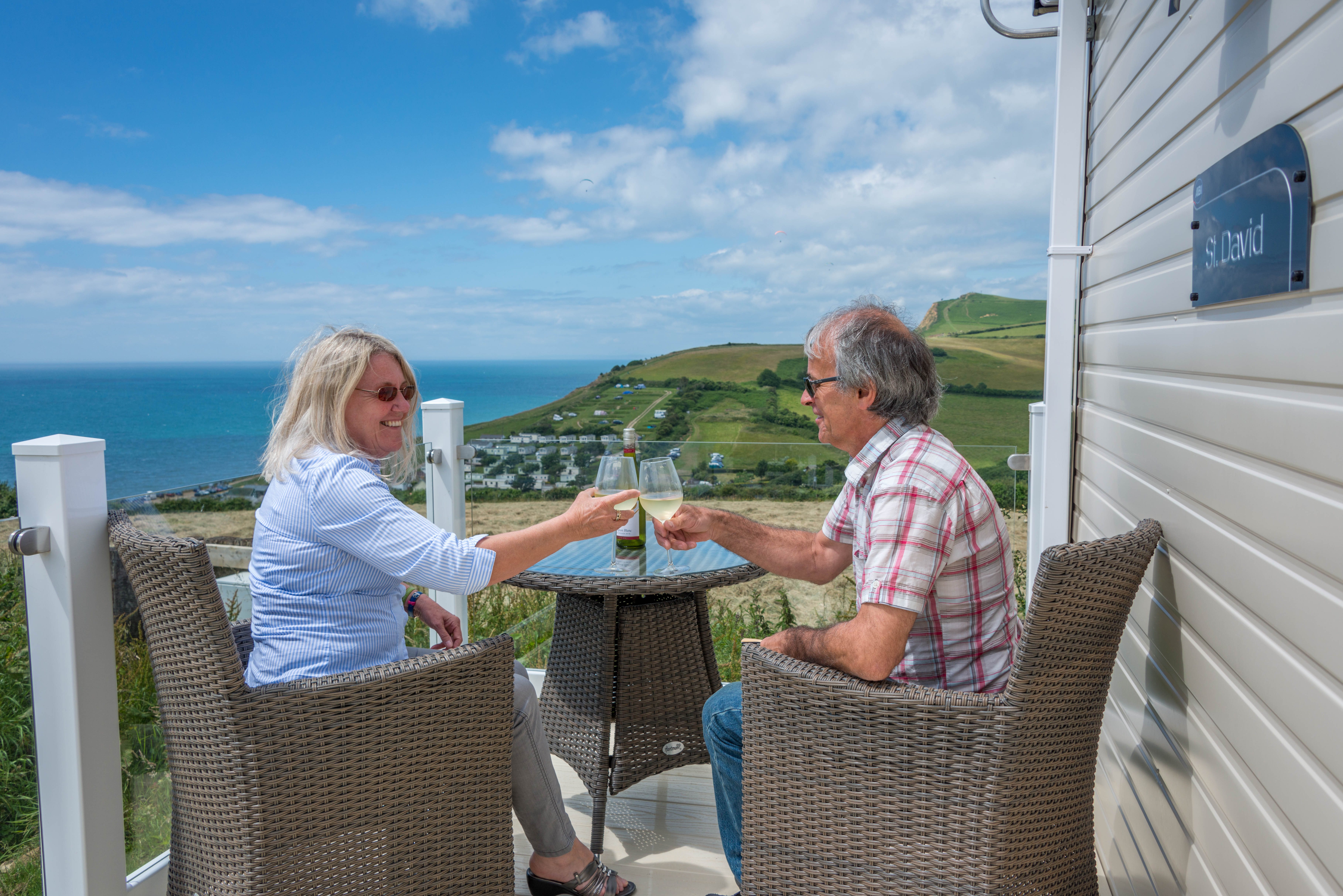 Couple enjoying a glass of wine on the verandah of a caravan holiday home